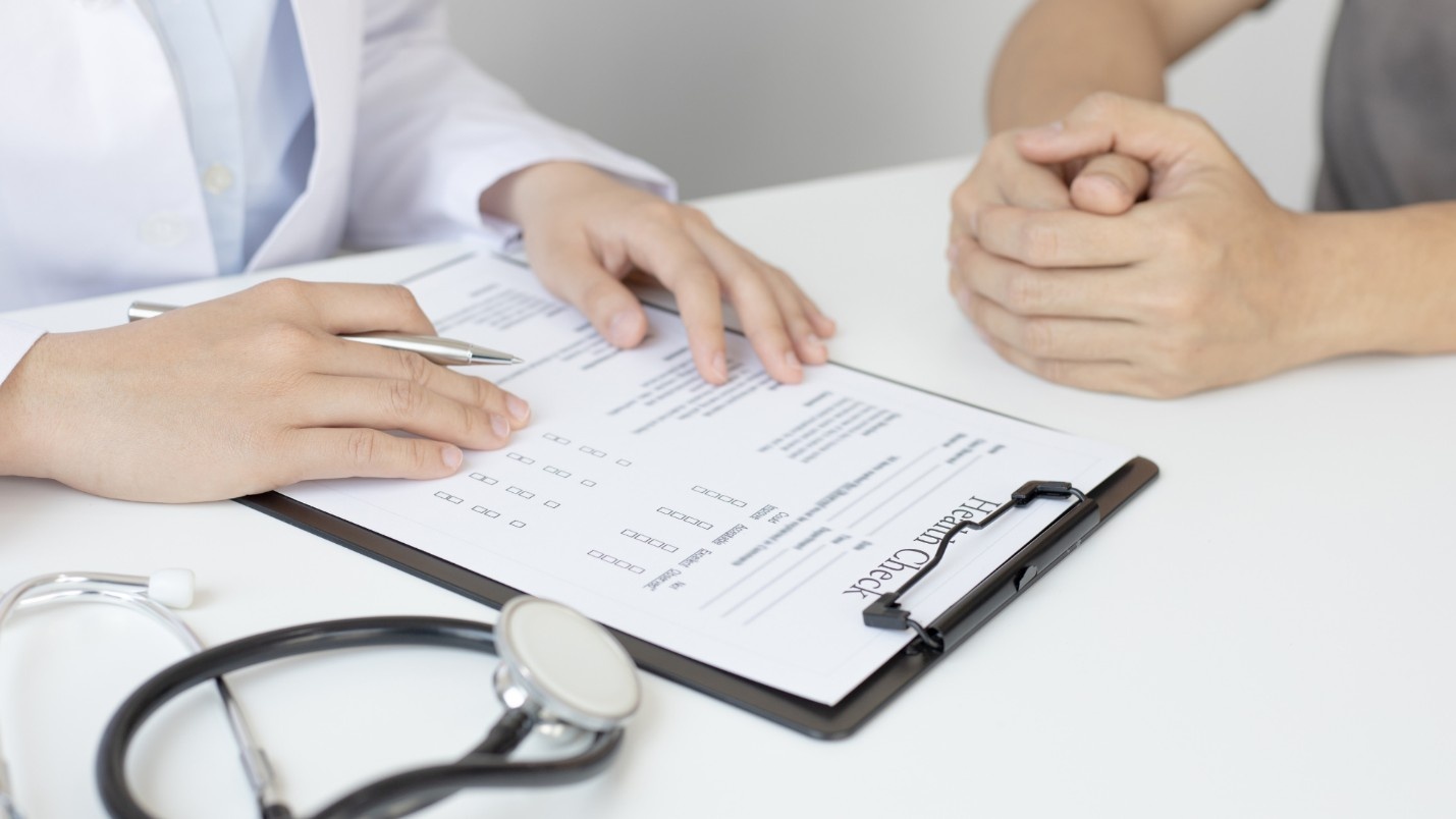 A clip board with a “Health Check” paper on it and a stethoscope.